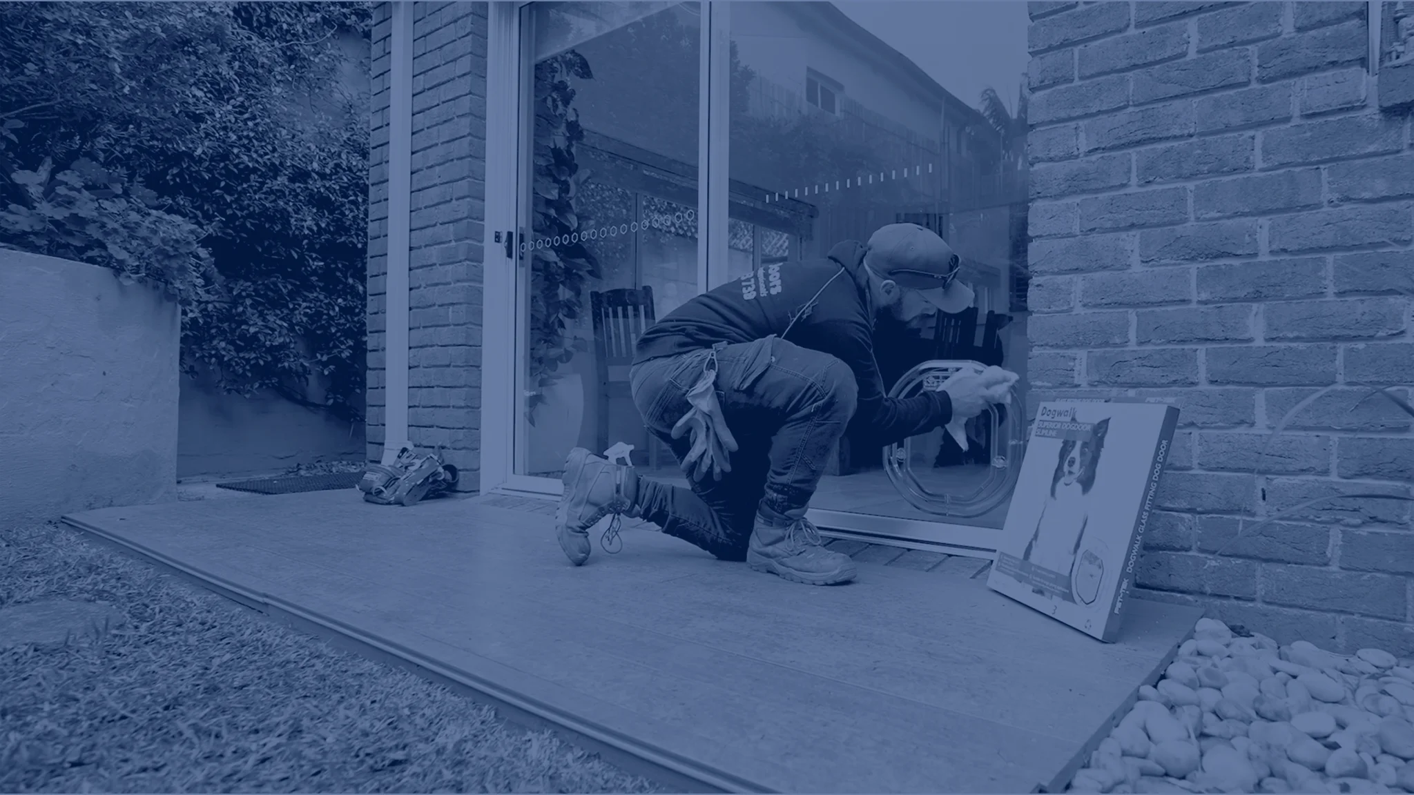 Worker installing dog door in glass door